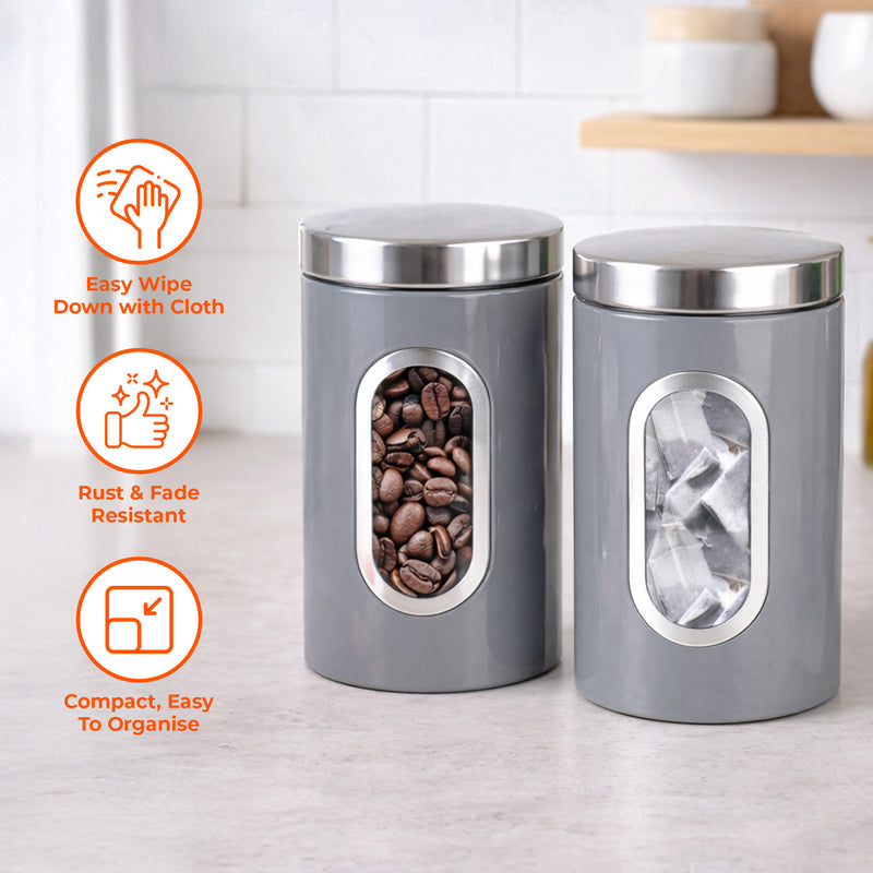 Two gray canisters with silver lids on a kitchen counter, featuring icons and text about their features.